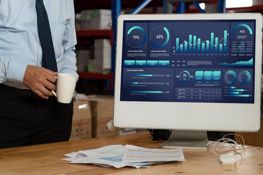 Professionnel analysant des données comptables sur plusieurs écrans en entreprise.