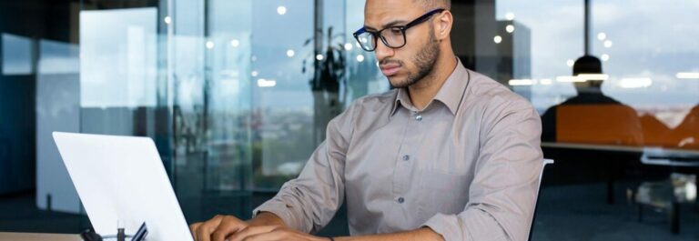Employé travaillant sur ordinateur portable dans un bureau moderne